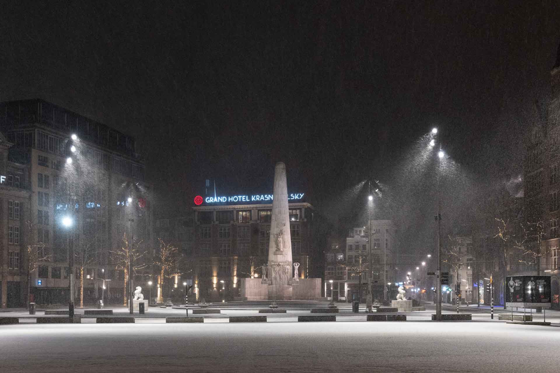 Avondklok Amsterdam sneeuw corona Monument Dam