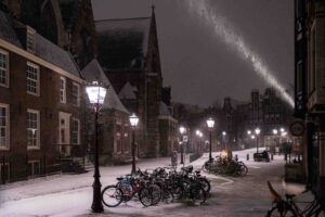 Avondklok Amsterdam sneeuw corona Oudekerksplein Wallen