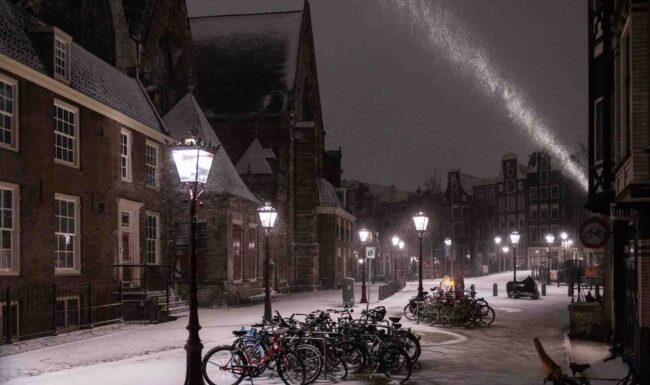 Avondklok Amsterdam sneeuw corona Oudekerksplein Wallen